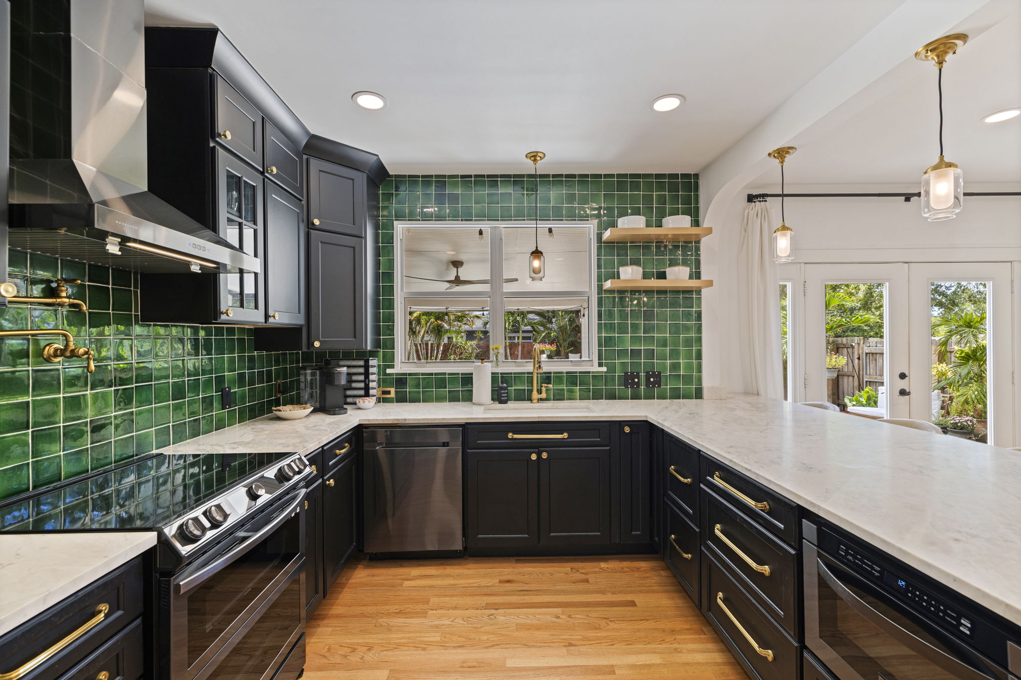 Kitchen with deep green cabinetry and handmade tile